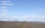 Cover of Voices May 2021issue looks of early spring trees under blue skies with a mountain range in the distance.