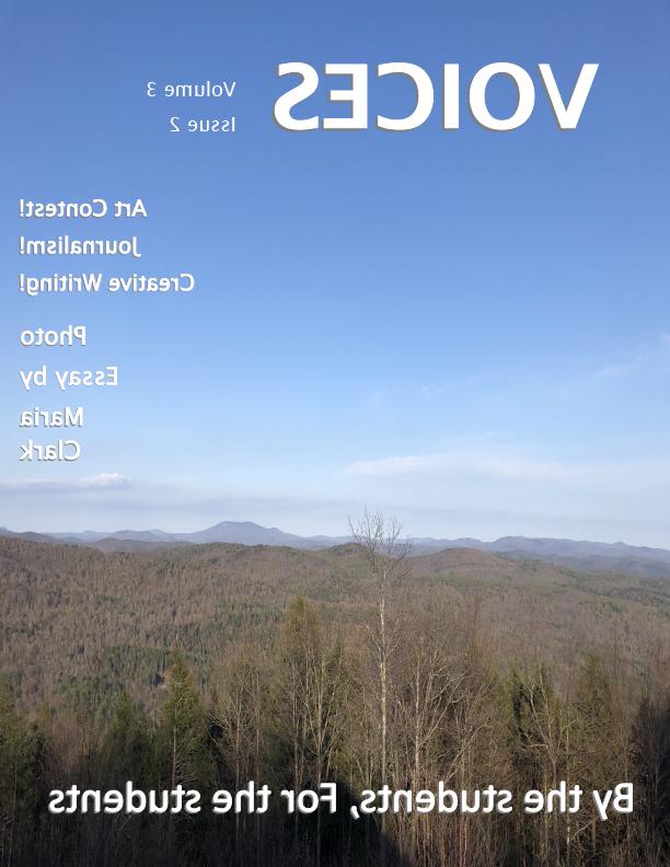 Cover of Voices May 2021issue looks of early spring trees under blue skies with a mountain range in the distance.